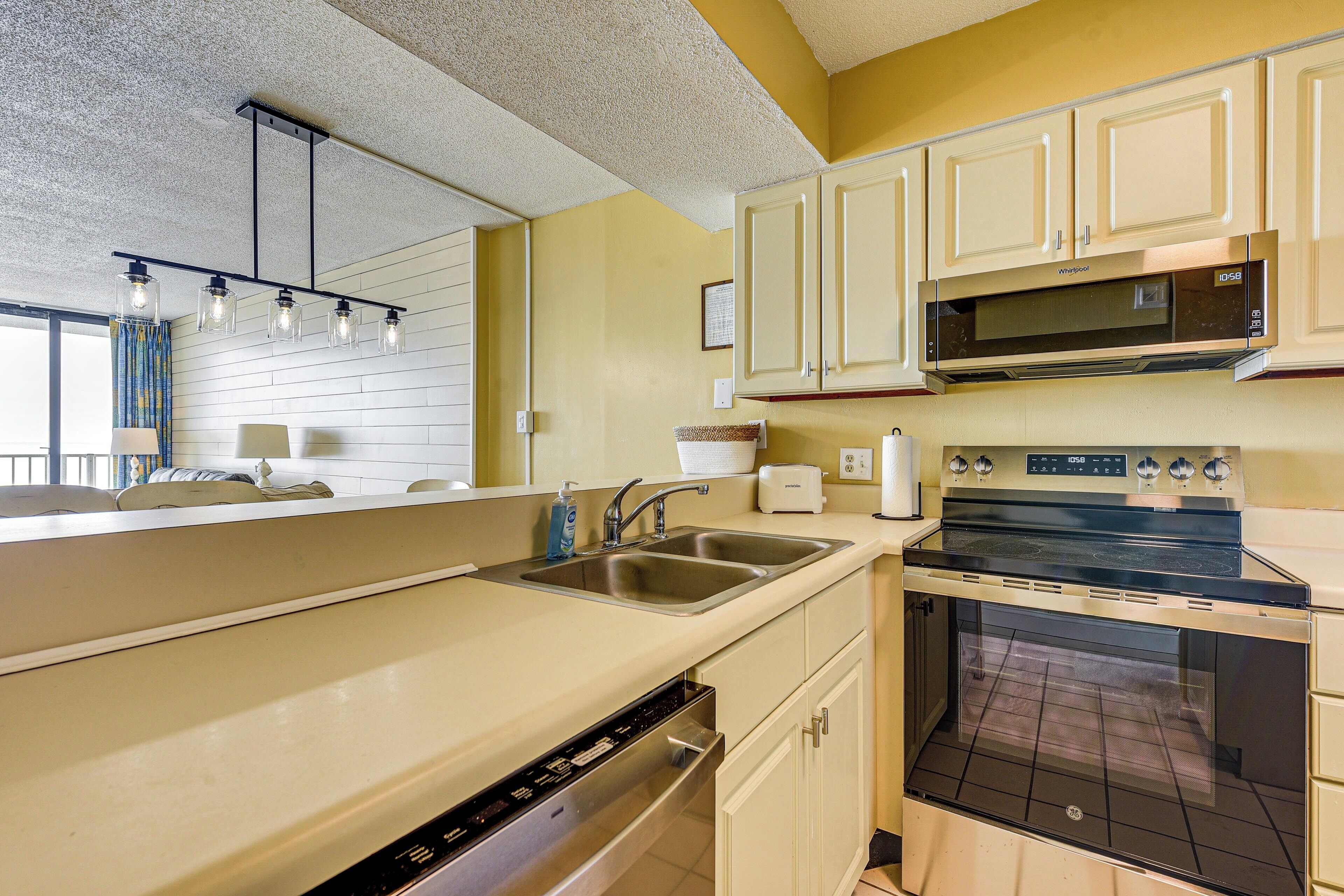 A kitchen with a dishwasher, sink, microwave, stove, and oven.