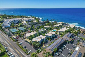 An aerial view of a coastal hotel complex with multiple buildings, parking areas, and a view of the ocean. - Top Floor Oceanfront Condominium in Kailua-kona (Kailua-Kona)