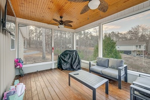 A covered porch with a ceiling fan, a sofa, a table, and a covered grill. - Lakefront Getaway w/ Boat Slip & Dock in Sparta! (Milledgeville)