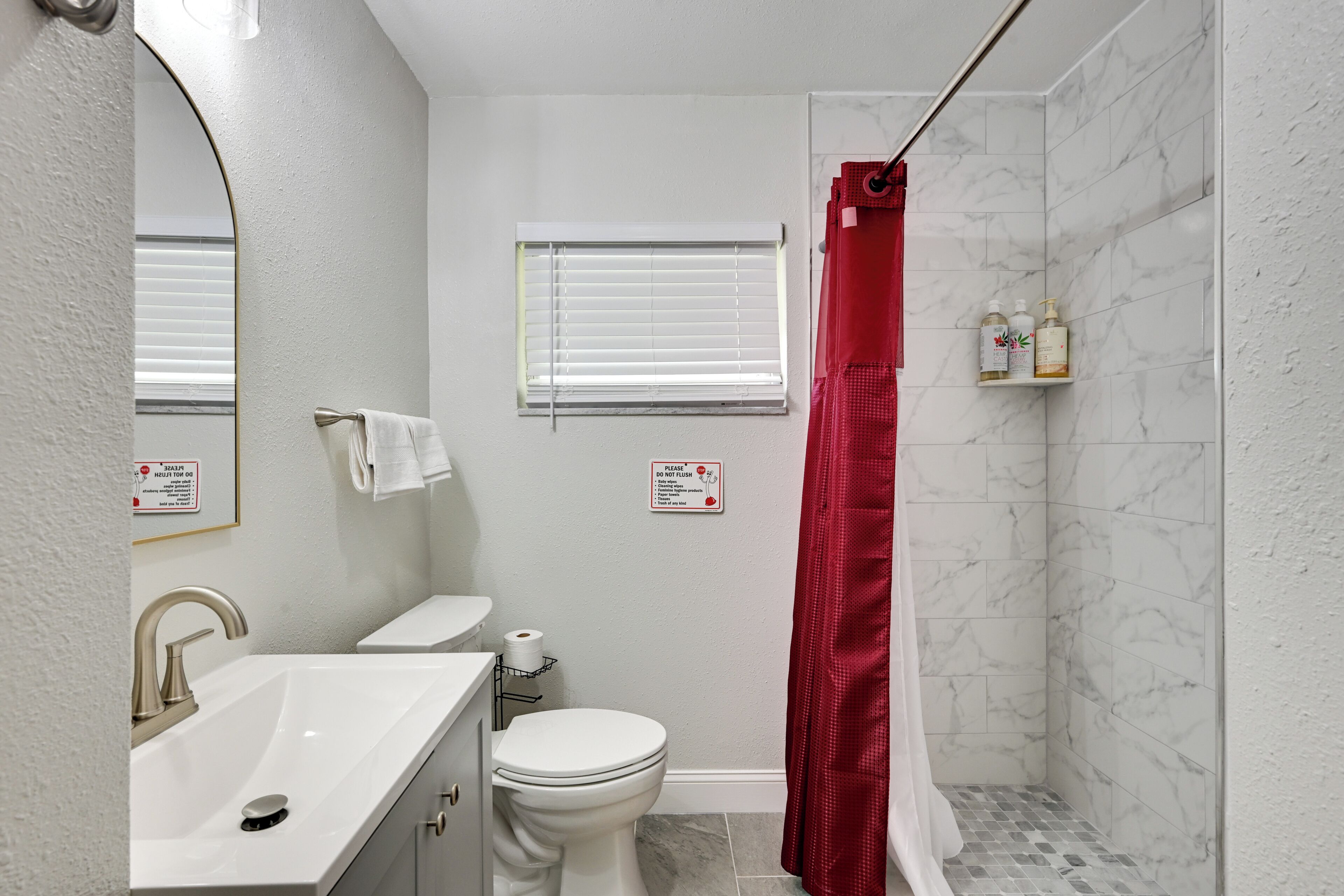 Un baño con lavamanos blanco, inodoro y cortina de ducha.