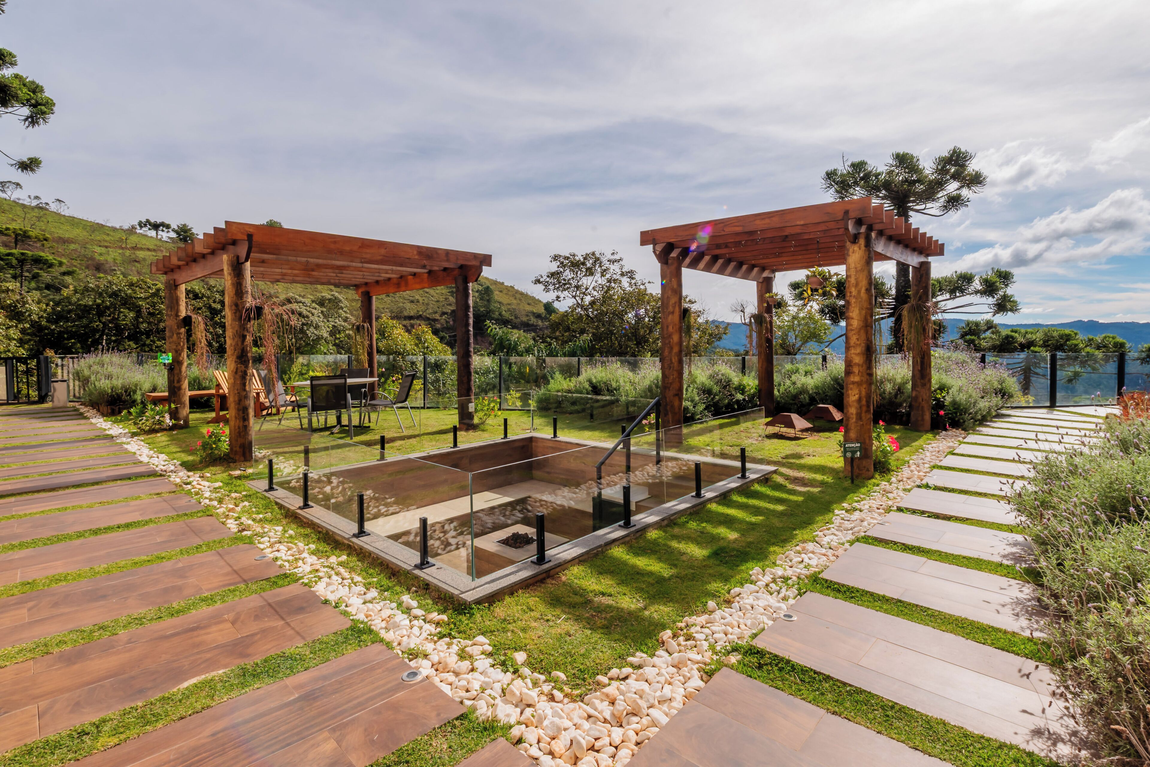 Uma estrutura de pérgola de madeira com área de estar e lareira.