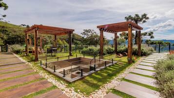 Uma estrutura de pérgola de madeira com área de estar e lareira.