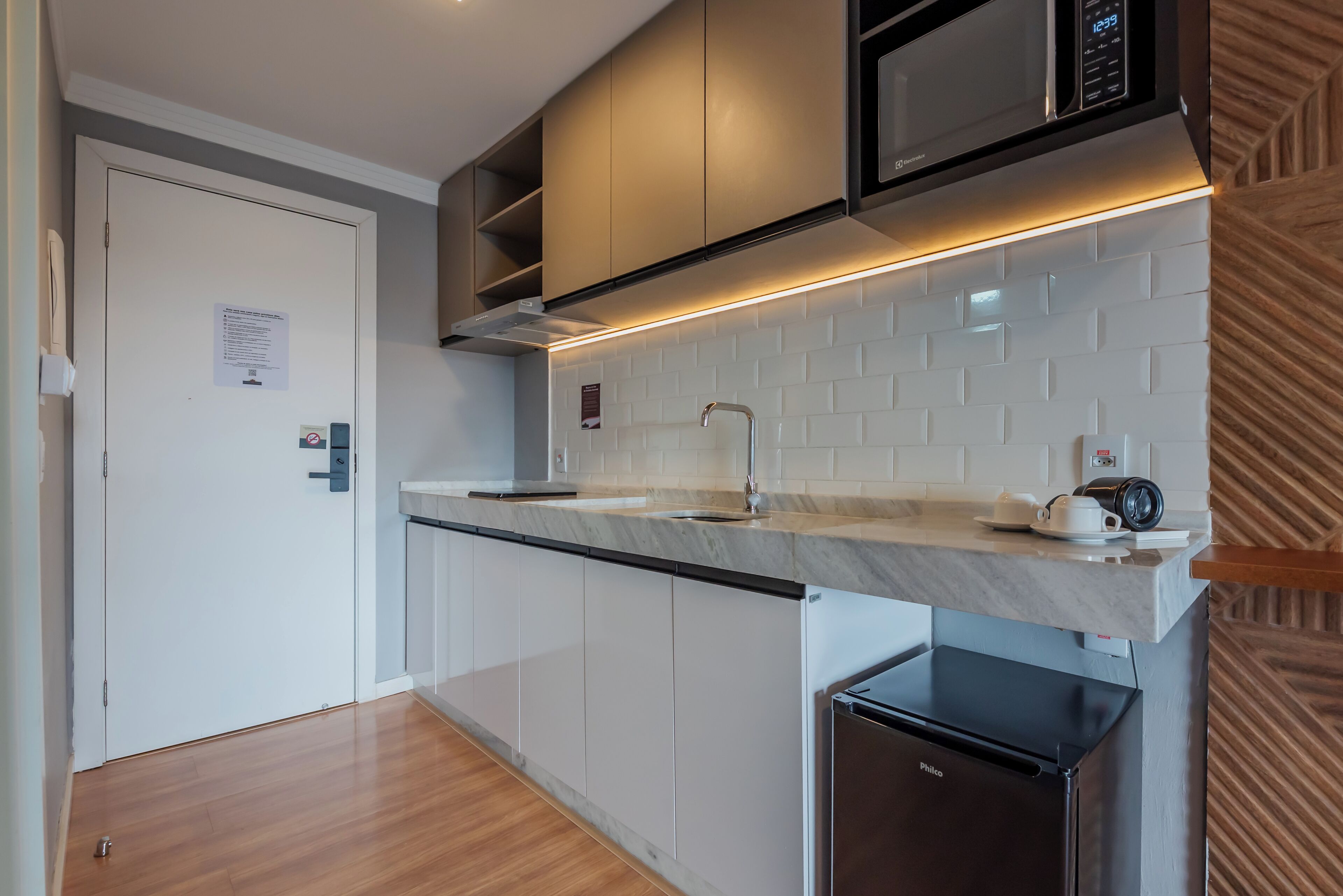 A modern kitchen with a microwave, sink, and refrigerator.