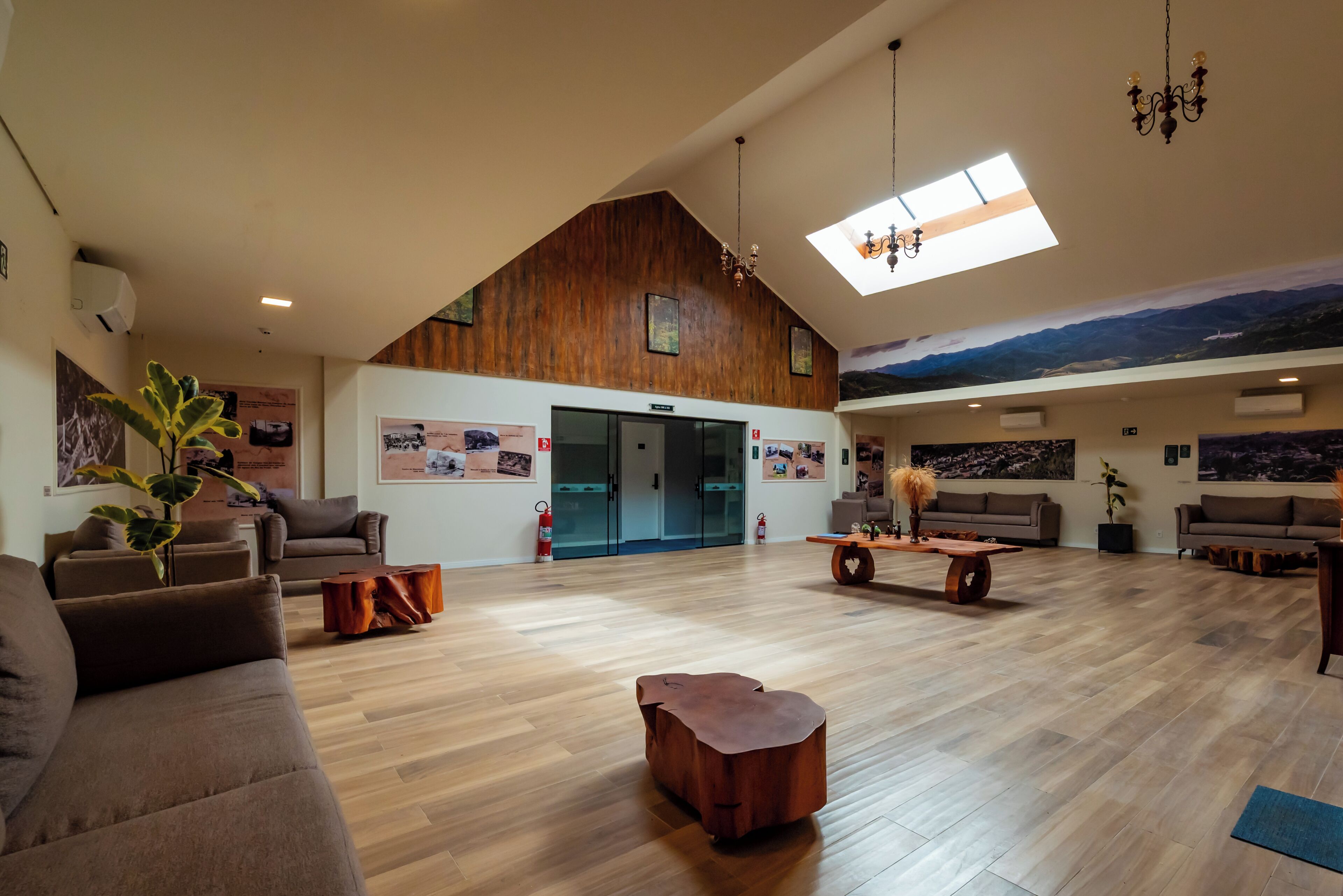 Een ruime woonruimte met een hoge plafond, houten details en een groot muurdecoratie.