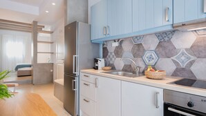 A modern kitchen with light blue cabinets, a stainless steel refrigerator, a built-in oven, and a tiled backsplash. - Michael Zeppos Studio 1, Naousa (Naousa)