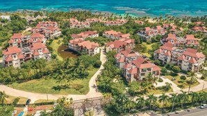 Un complexe hôtelier comprenant plusieurs bâtiments, une plage et offrant une vue dégagée sur l’océan.