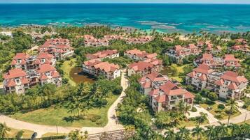 Un resort con varias construcciones, una playa y una vista despejada del océano.