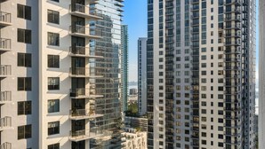 A high-rise building with multiple balconies and a modern architectural design. - Crosby Miami WTC 2BR/2BA Top Floor Residence #3214 (Miami)