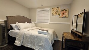 A bedroom with a bed, bedside table, and a mirror.