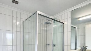 A modern bathroom with a glass-enclosed shower, a white toilet, and a sink with a mirror above it. - Zen Marina Rm Bayview - Shared Pool - Central (Darwin)
