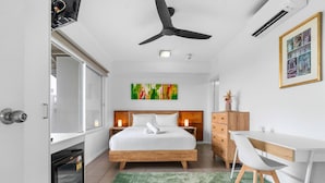 A modern hotel room with a bed, desk, chair, and a ceiling fan. - Zen Marina Rm Bayview - Shared Pool - Central (Darwin)