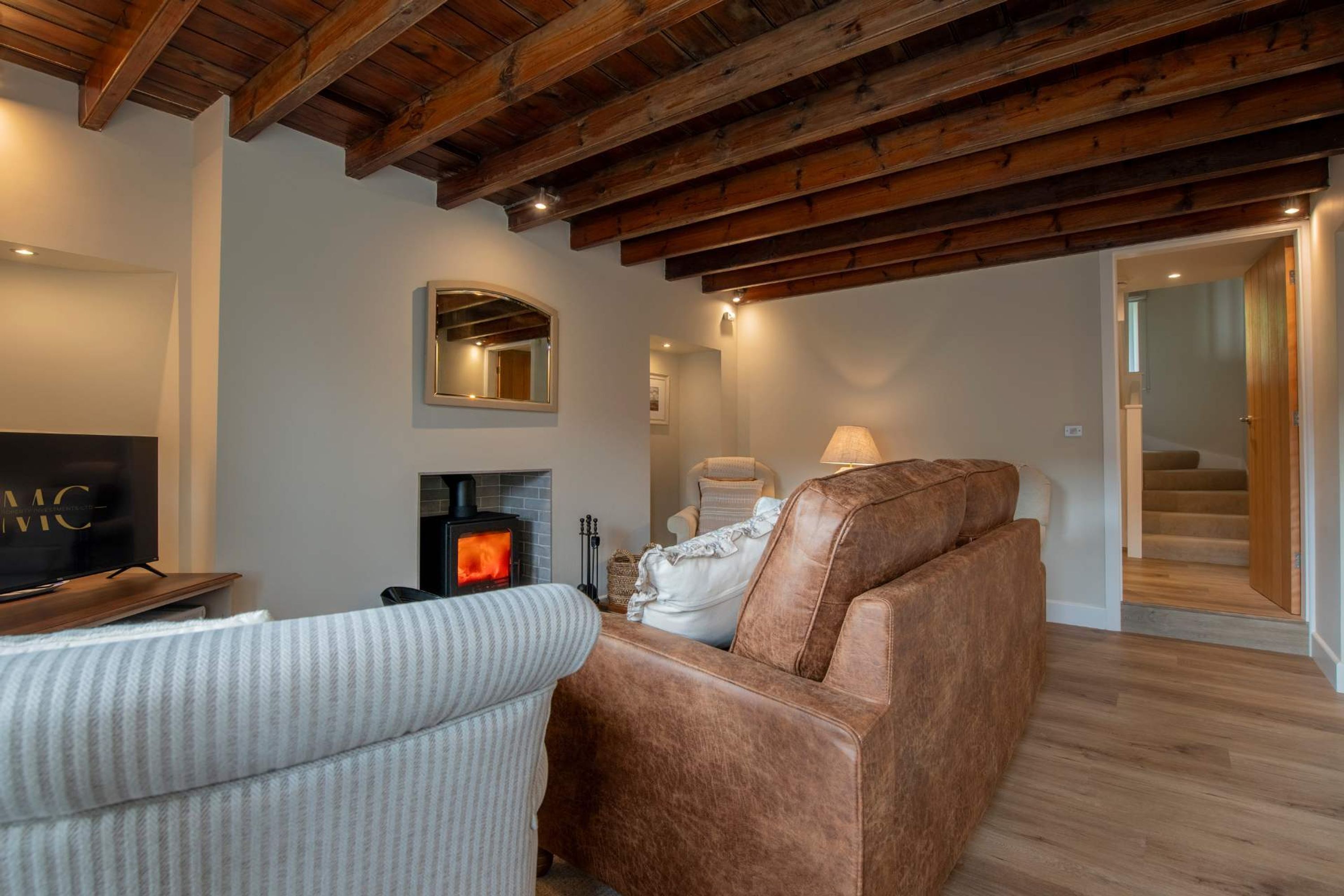 A cozy living room with a fireplace, a television, and a sofa.