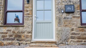 A stone building with a white door, two windows with brown frames, and a 'Hill House' sign. - Charming Countryside Cottage Yorkshire Dales (Richmond)