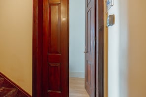 A wooden door leading to a hallway with a light switch and a wall-mounted device. - City Center Terrace Apartment by Vacationy (Porto)
