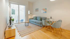 Ein modernes Wohnzimmer mit einer Couch, einem Esstisch, Stühlen und Kunstwerken an den Wänden.