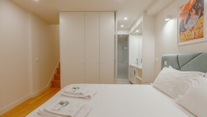 Ein Hotelzimmer mit Bett, Badezimmer, Treppe und einem Gemälde an der Wand.
