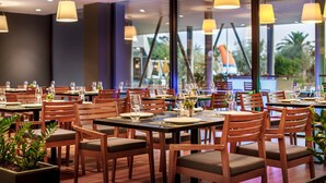 A restaurant with wooden tables and chairs, large windows, and hanging pendant lights. - Mobile Home in Rabac With Shared Pool (Labin)