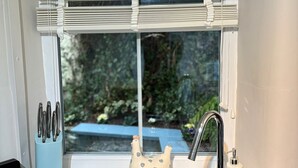 A kitchen with a sink, faucet, and window with blinds. - Charming Holiday Retreat in Derbyshire Countryside (Matlock)