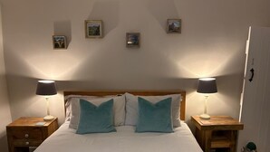 A neatly made bed with a striped pillowcase, two bedside lamps, and a wooden nightstand with a drawer. - Charming Holiday Retreat in Derbyshire Countryside (Matlock)