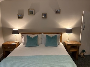 A neatly made bed with a striped pillowcase, two bedside lamps, and a wooden nightstand with a drawer. - Charming Holiday Retreat in Derbyshire Countryside (Matlock)