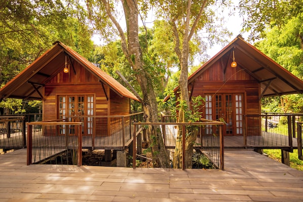 Two wooden cabins with balconies, surrounded by trees and a wooden deck. - Chale da Arvore (Belém)