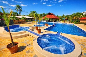 A swimming pool with multiple hot tubs, palm trees, and a gazebo. - 5-Min Walk to Jacó Beach  Shops, Tours & Dining Nearby (Jaco)
