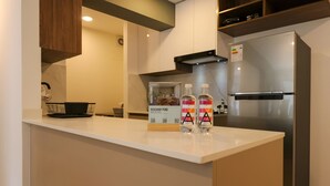 Eine moderne Küche mit einem eingebauten Kühlschrank, einer weißen Arbeitsplatte und einem schwarzen Drahtkorb.
