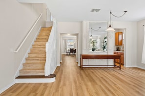 A staircase leading to a dining area with a wooden table and chairs. - Spacious 6BR home w/ pool & BBQ grill (Kissimmee)