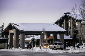A hotel with a covered entrance, brick facade, and snow on the roof. - Park City Peaks (Park City)
