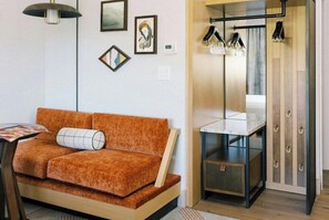 A modern room with a sofa, a small table, a mirror, and a cabinet. - Park City Peaks (Park City)