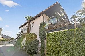A house with a balcony, a staircase, and a hedge. - Casa Viola Panorama in Losone for 4 (Losone)