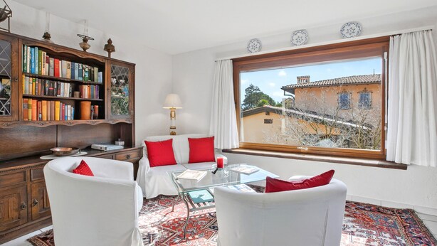 A room with a large window, a bookshelf, a sofa, and a glass table. - Casa Viola Losone for 8 (Losone)