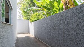A narrow outdoor corridor with a textured wall and a concrete floor. - Apts in Condominium w/ Pool 450 Meters fr/ Taperapuan Beach - Atas (Porto Seguro)