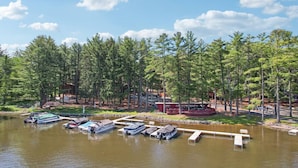 A lakeside property with docked boats, a covered picnic area, and a cabin. - Johnny`s Lucky 13 at Island Pointe (Wisconsin Dells)