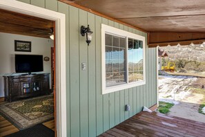 A room with a television, a cabinet, a window, and a view of a construction site. - 10 Mi to Tehachapi Mountain Park: Mtn-View Cabin! (Tehachapi)