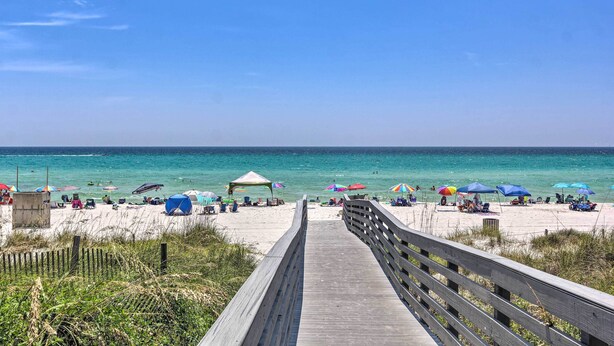 A wooden boardwalk leading to a beach with umbrellas and beach chairs. - Walk to Shore: Townhome w/ Pool Access in PCB! (Panama City Beach)