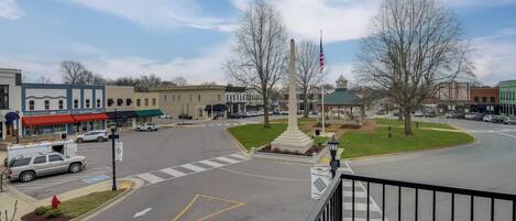 A street view with a monument, a flag, and a 'Welcome to' sign.