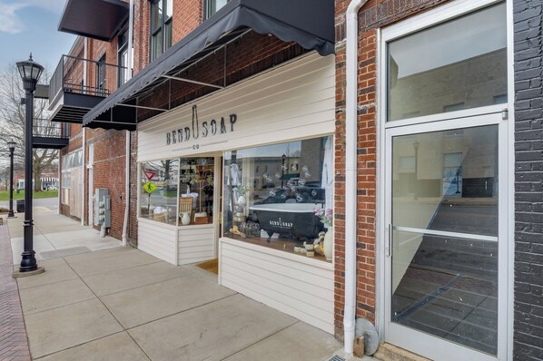 A storefront with a sign reading 'BENZO SOAP' and a large glass window displaying various products.