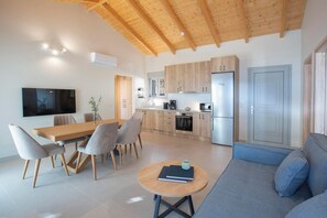 A modern living space with a dining area, kitchen, and seating area. - Ponti Monti - Two Bedroom Villa, Sleeps 4 (Vasiliki)