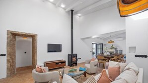 A spacious living room with a fireplace, a dining area, and a modern kitchen. - Vista Azul - Five Bedroom Villa, Sleeps 10 (Loulé)