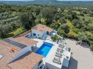 A modern villa with a swimming pool, solar panels, and a view of the surrounding countryside. - Vista Azul - Five Bedroom Villa, Sleeps 10 (Loulé)