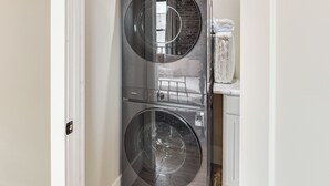 Un appareil combiné lave-linge et sèche-linge, fixé au mur, avec une étiquette indiquant clairement le prix.