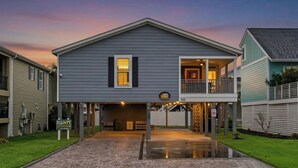 A two-story house with a covered front porch and a garage. - Coastal Serenity-3BR Luxury Home in Cherry Grove (North Myrtle Beach)