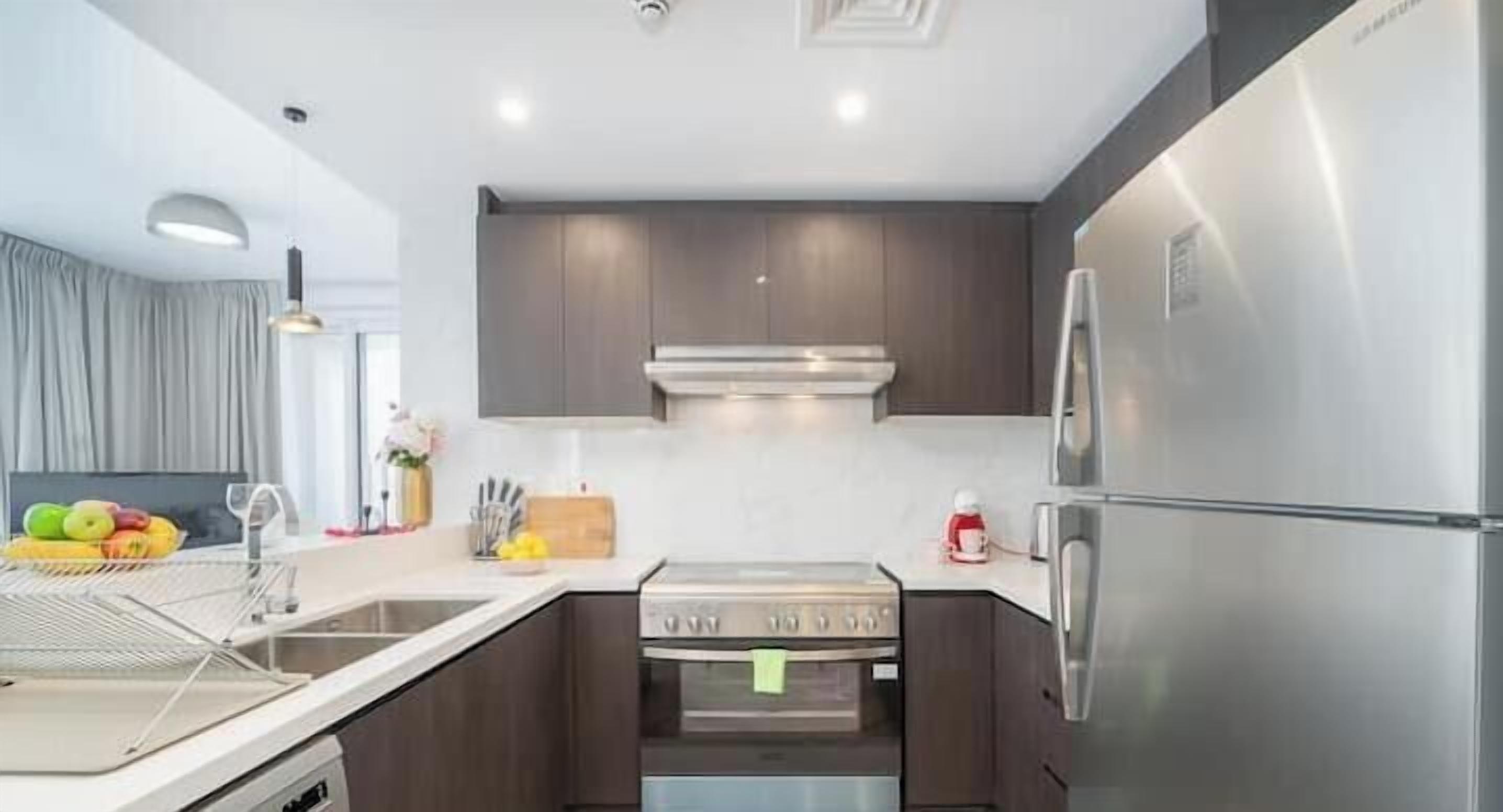 A modern kitchen with stainless steel appliances, a built-in oven, and a microwave.