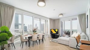 A modern living room with a dining area, large windows, and a city view. - Vogue | Al Wasl 1 Residence near World Trade Centre (Dubai)