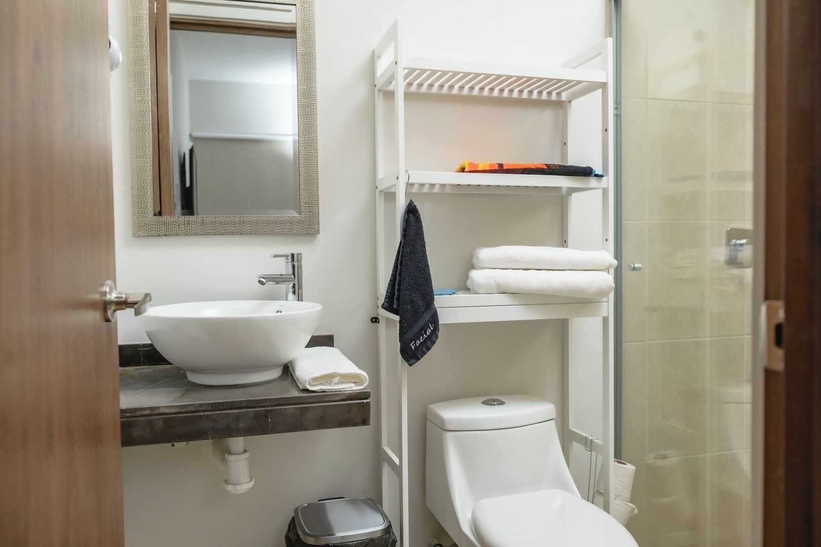 A bathroom with a sink, toilet, and a shower area.