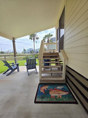 A covered porch with a wooden staircase, two Adirondack chairs, and a fish-themed doormat. - Charming 2-bedroom House Near Rockport's Downtown Cultural District (Rockport)