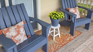 A porch with two blue Adirondack chairs, a small white stool, and a potted plant. - Charming 2-bedroom House Near Rockport's Downtown Cultural District (Rockport)