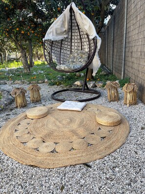 A garden area with a hanging chair, woven poufs, and a round woven mat. - casa bella himara (Himare)