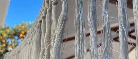 Un tapiz de macramé con flecos colgando del techo.